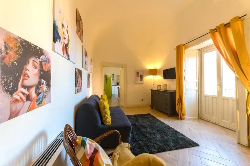 Living room with blue sofa, rug and yellow curtains