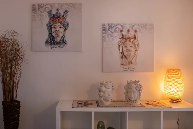 Moor’s head ceramics and lamp on a white shelf