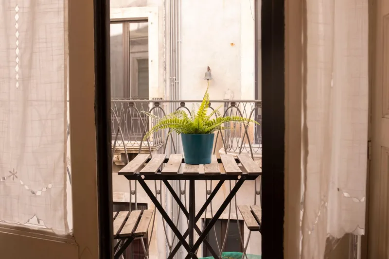 Balcony table with fern seen through the doorway