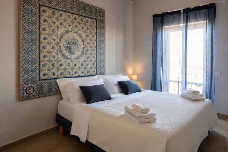 Bedroom with tile tapestry and balcony door