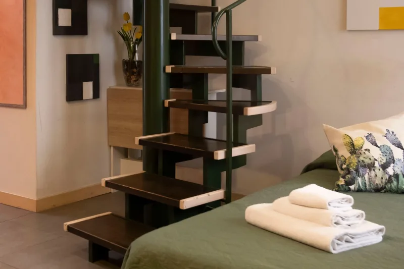 Bed beside the open spiral staircase