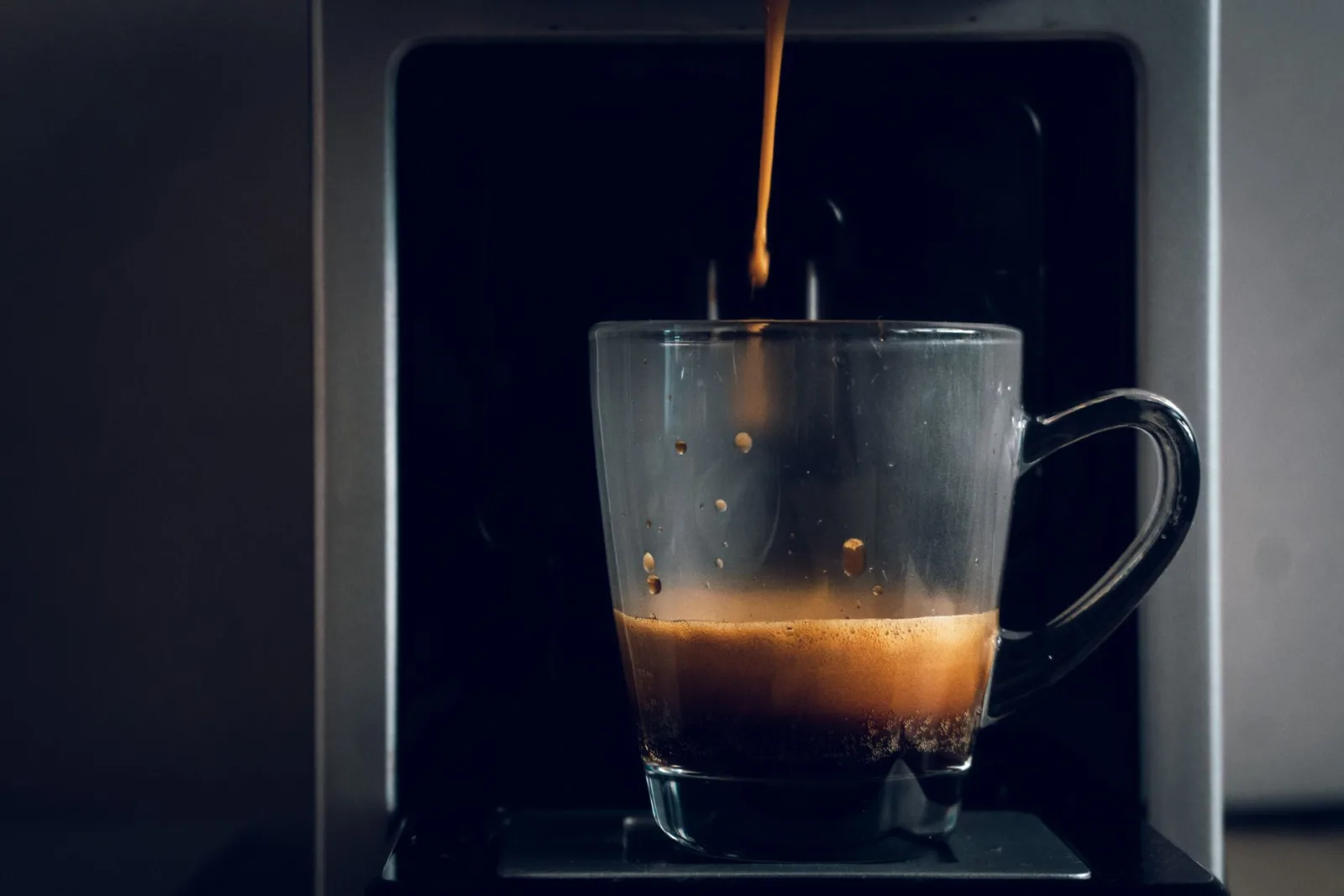 Espresso pouring into a glass cup
