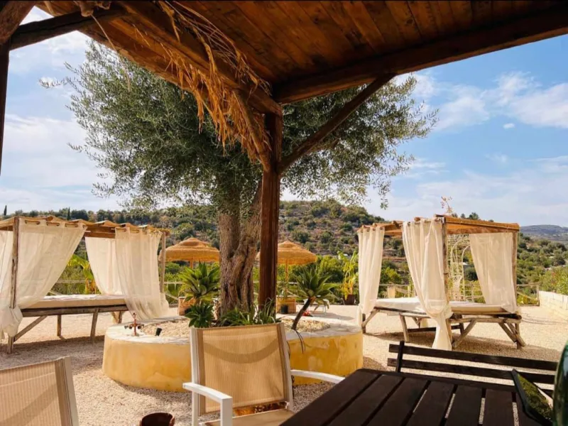 Olive tree and curtained gazebos overlooking the countryside